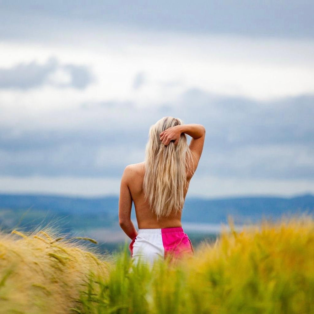 
                  
                    Person wearing white and pink canterbury shorts and looking at the landscape
                  
                