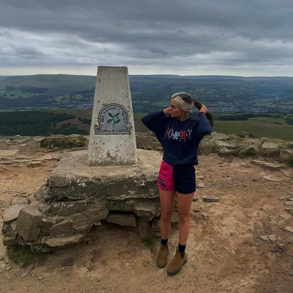 
                  
                    Woman wearing Canterbury harlequin shorts standing next to a landmark
                  
                