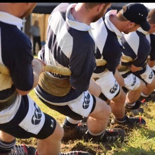 Men wearing Canterbury harlequin shorts and pulling a tug rope